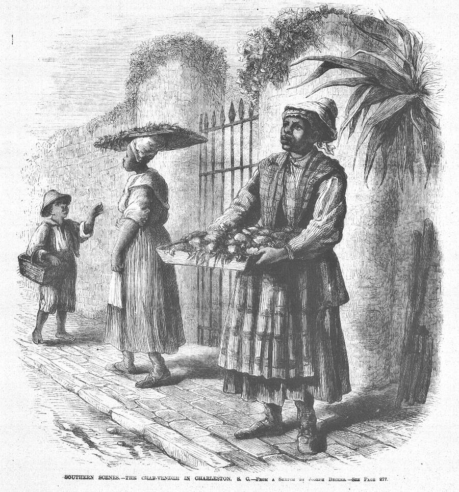 Engraving of two Black street vendors in a Charleston lane. One carries a tray of crabs; behind her, another woman carries a basket on her head and a boy carries a small basket.
