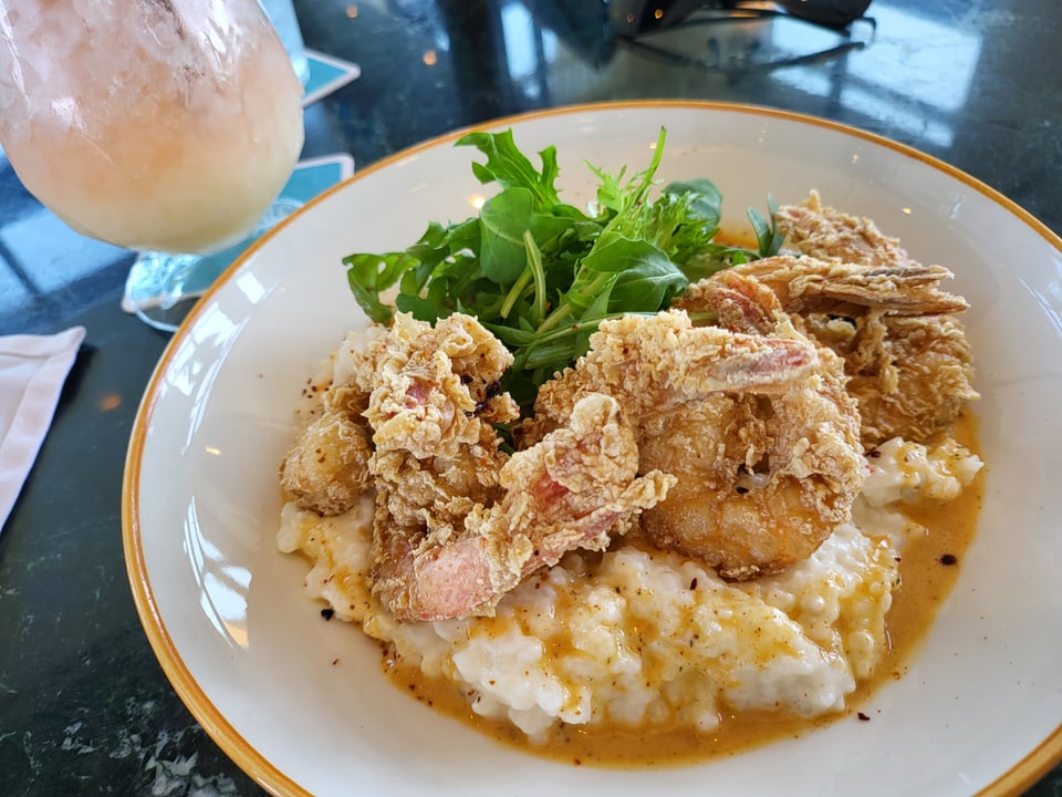 Fried shrimp over creamy rice with greens at Bar Julian.