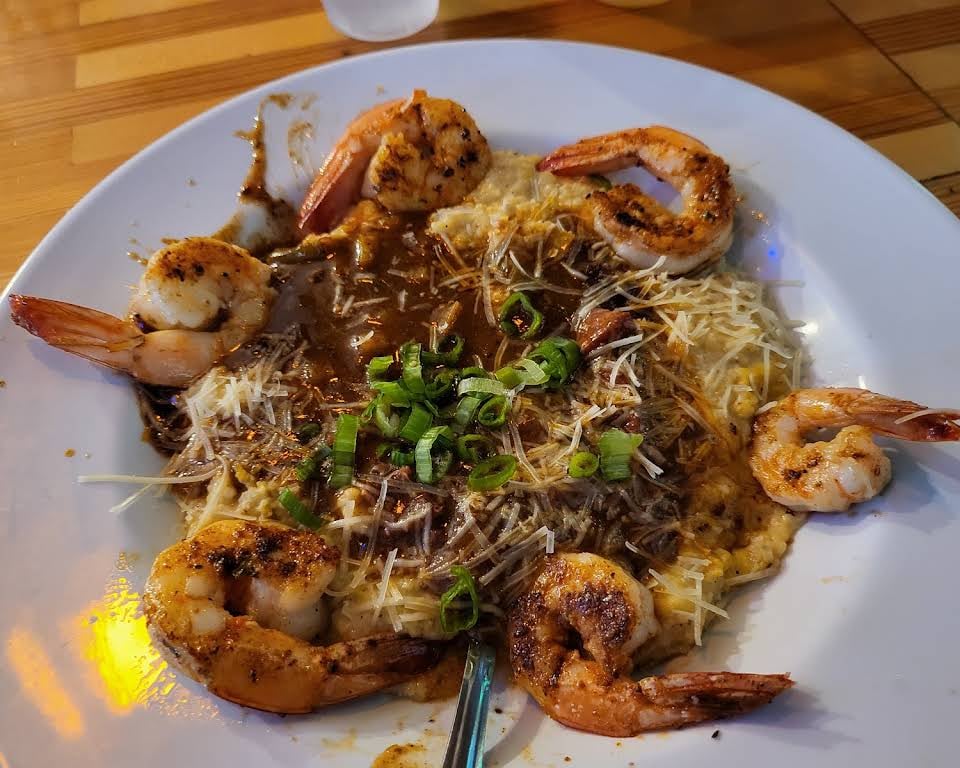 Six shrimp around grits with brown sauce, grated cheese, and green onions at Bubba Gumbo's.