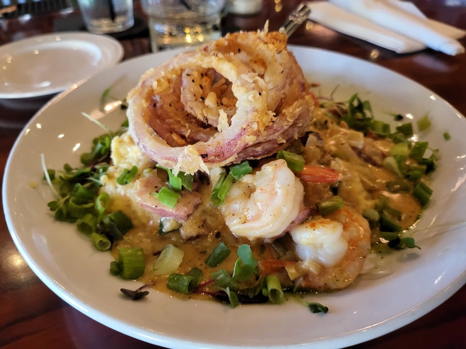Shrimp and grits topped with onion rings at Castaways Sandfly.