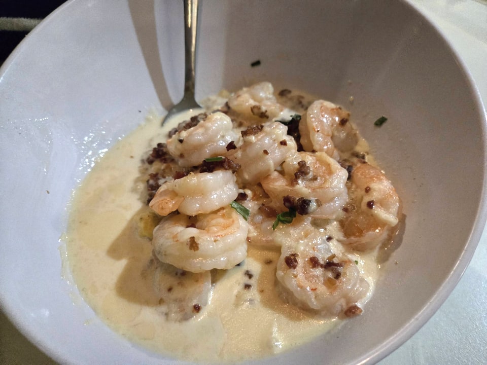 Grilled shrimp in a cream sauce in a white bowl at Driftaway Cafe.