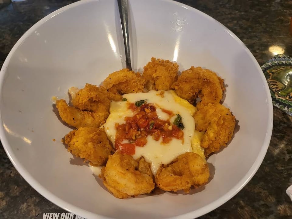 Fried shrimp surrounding grits with cream sauce and tomato compote at Driftaway Cafe.