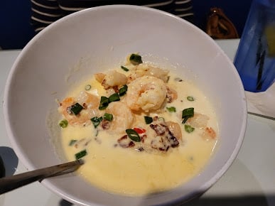Shrimp and grits in a white bowl at Driftaway Cafe.
